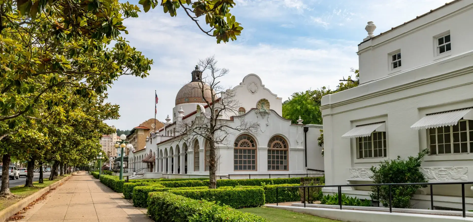 Historic white building with tree-lined sidewalk