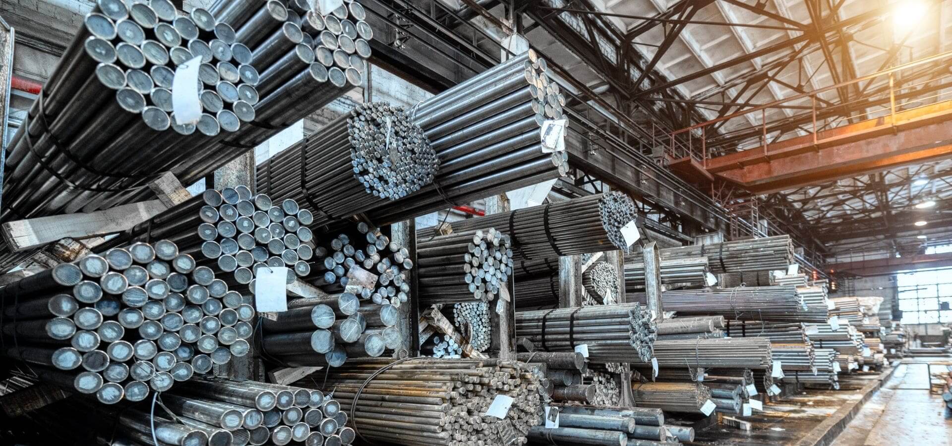 Steel pipes stacked in a large warehouse.