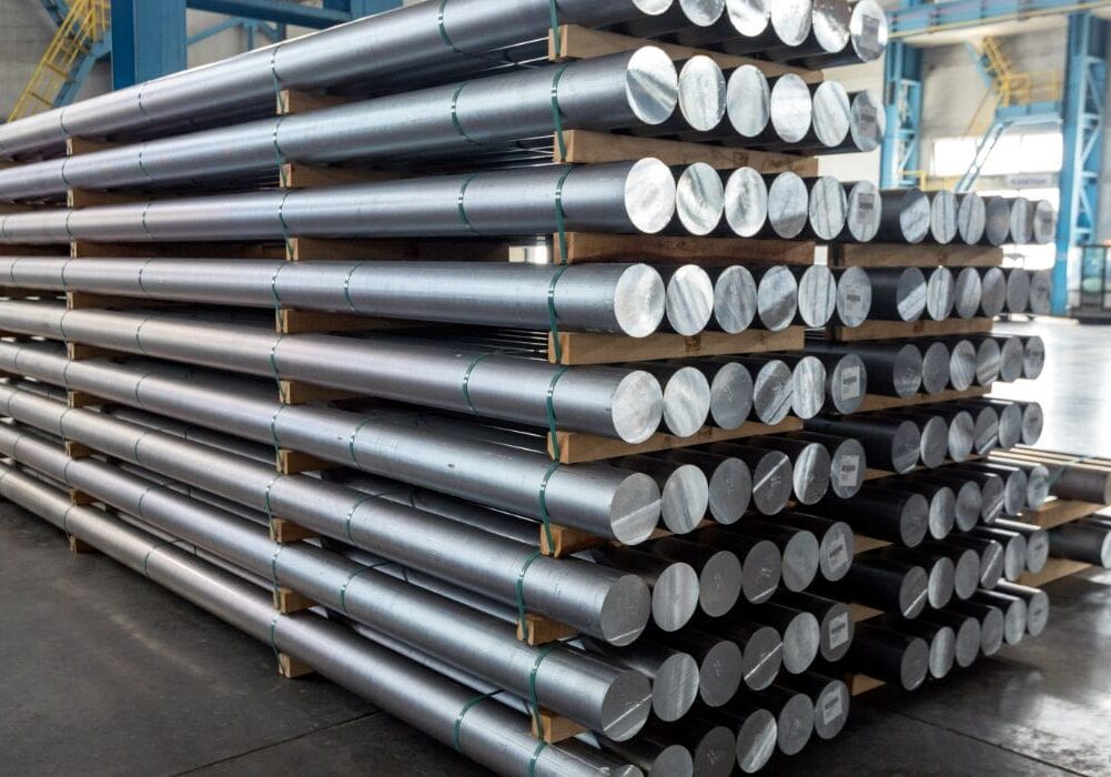 Stacked aluminum rods in a warehouse.